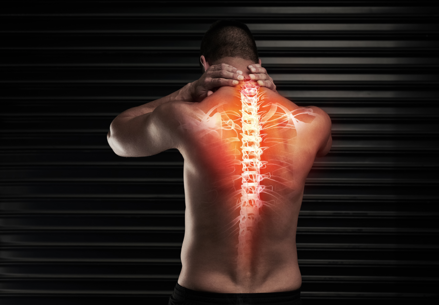 His back is a little out of sorts. Rearview shot of an athletic young man suffering with a back injury in the studio