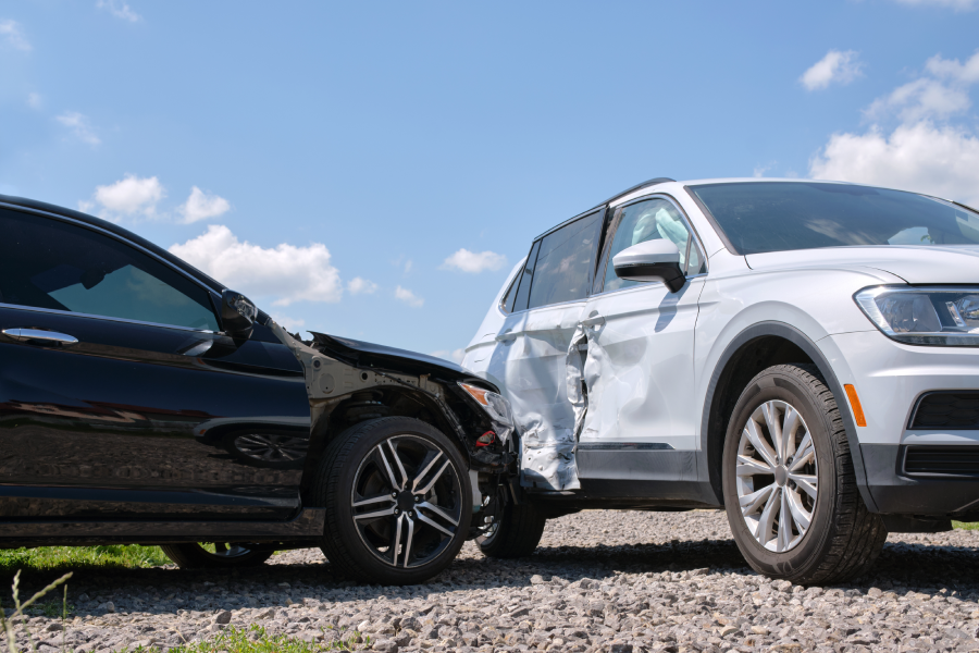 Damaged in heavy car accident vehicles after collision on city street crash site. Road safety and insurance concept