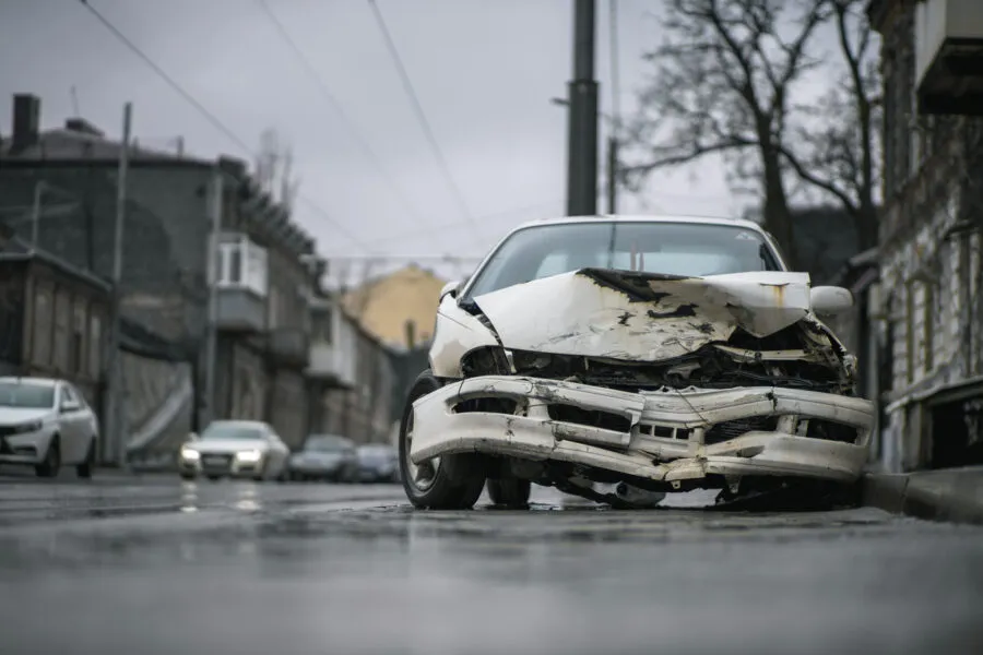 Auto accident on the street. A car damaged after a severe accident stands on a city street. Accident insurance concept.