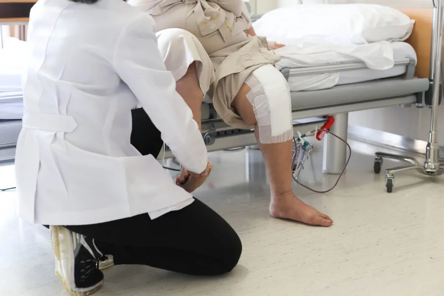 Doctor doing Physical therapy for Patient with a knee injury in hospital