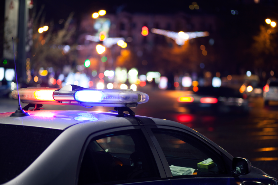 Danger on the road. Blue flasher on the police car at night.