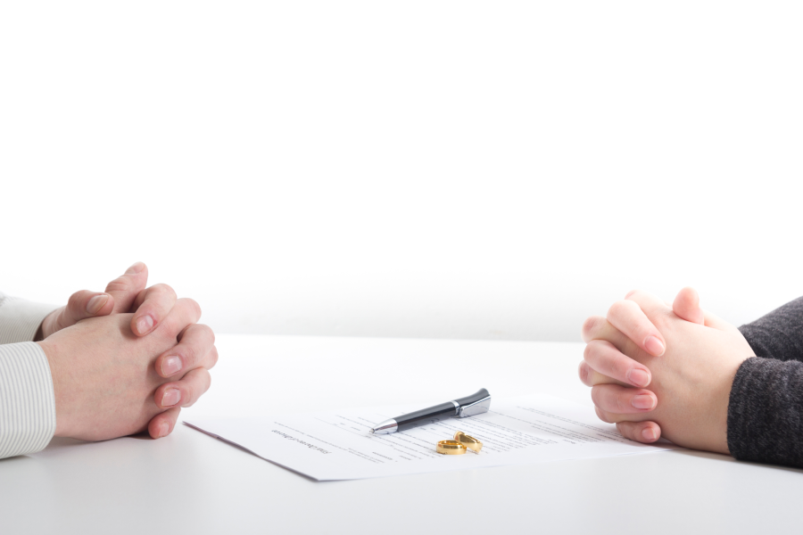 Hands of wife, husband signing decree of divorce, dissolution, canceling marriage, legal separation documents