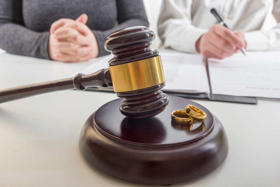 Hands of wife, husband signing decree of divorce, dissolution, canceling marriage, legal separation documents, filing divorce papers or premarital agreement prepared by lawyer.