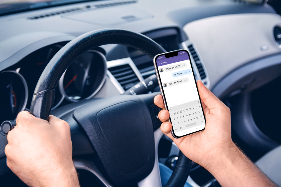 Young man driving a car with a phone in his hand. Don't text and drive. Distracted driving.