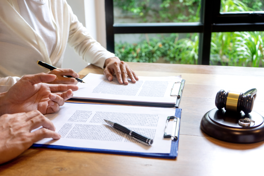 In the law firm, husband and wife signing in legal separation document, marriage law lawyer concept.