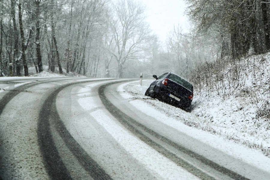 Abandoned car in the ditch after the traffic accident. Symbolises the dangerous conditions in winter with ice, snow and snatch.