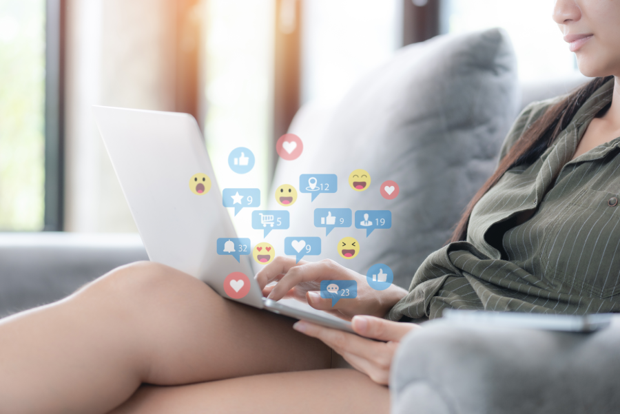 Social media and digital online concept, woman using computer laptop on sofa in the morning at home.