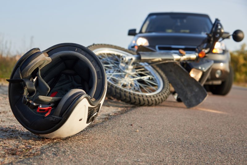 Photo of car, helmet and motorcycle on road, the concept of road accidents