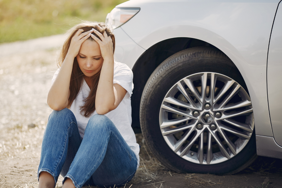 Woman by the car. Lady in a white t-shirt. Broken car. Woman need to help.