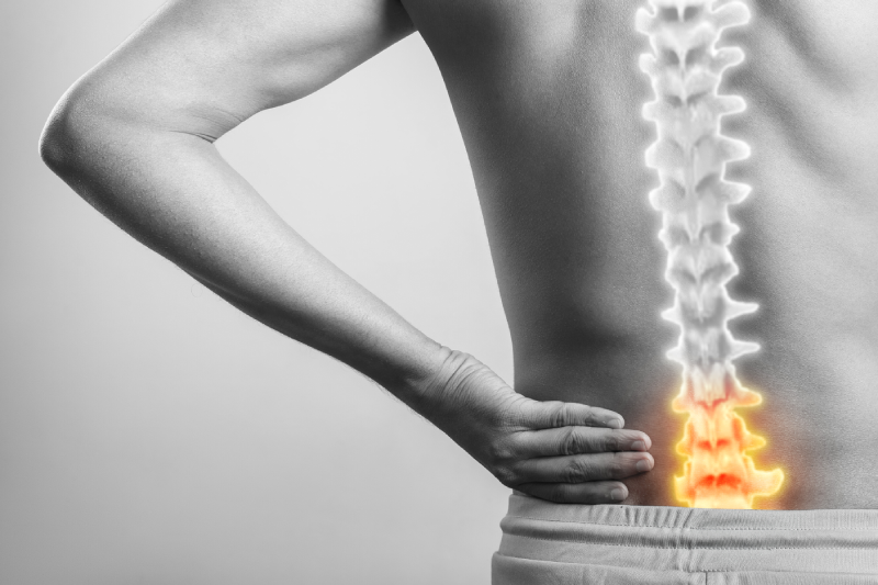 spinal cord anatomy injury, Young guy holding lower back injury pain highlighted in red glow isolated in white background