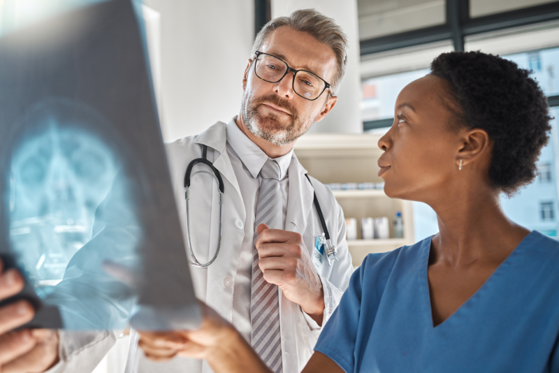 Brain, x ray and neurology doctors in a meeting working on a skull injury in emergency room in a hospital.