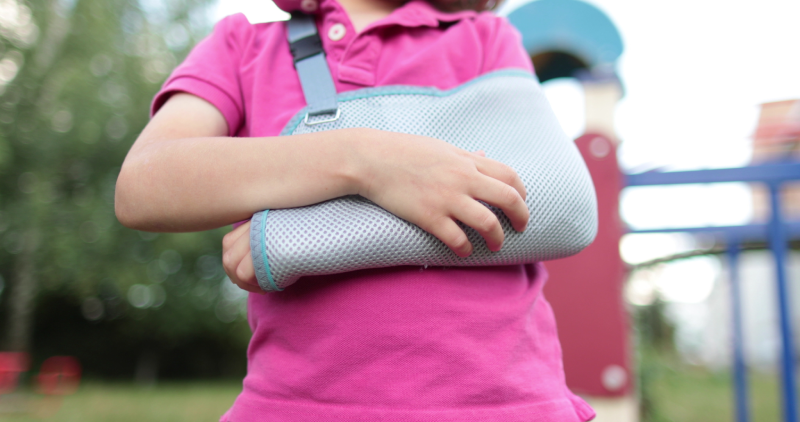 Close-up of a hand in a bandage. A boy with a bandage on his arm in an open space.