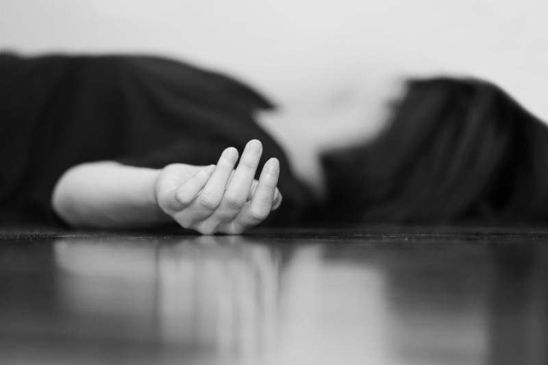 dead woman's body lying on the floor focus on hand