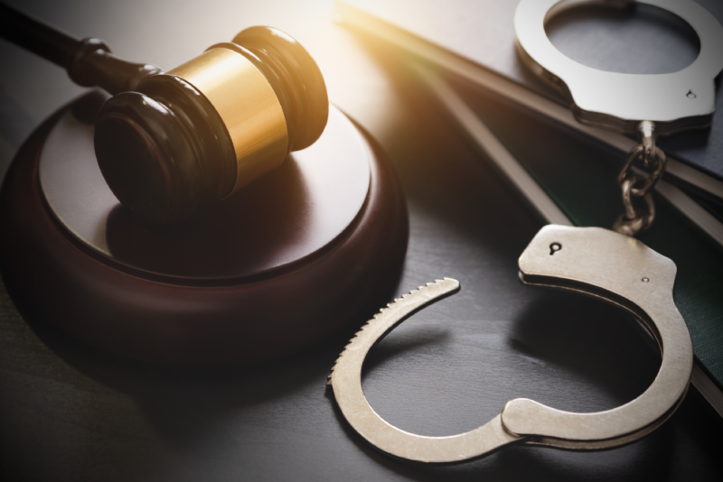 Handcuffs and wooden gavel. Crime and violence concept.